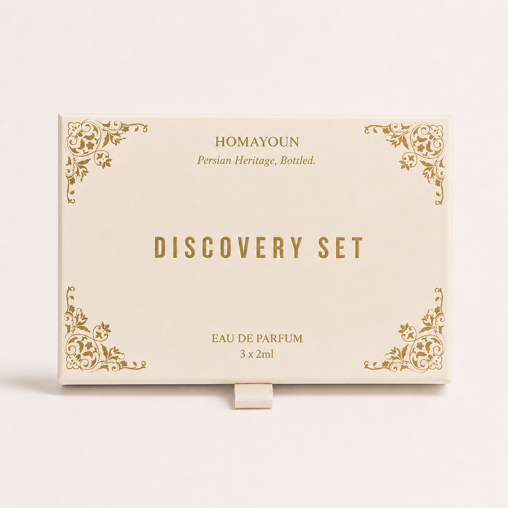 Homayoun Discovery Set Eau de Parfum box, featuring a cream-colored rectangular packaging with elegant gold ornamental corner designs and gold lettering, displayed on a matching cream background.